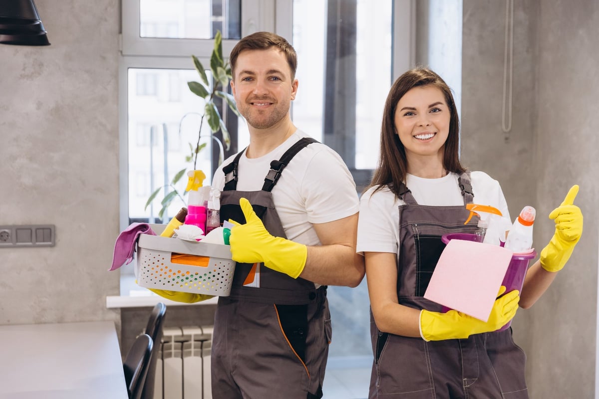 Professional cleaners with cleaning supplies